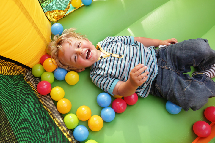 A laughing child in a bounce house having fun at a party